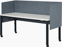 Front angle view of four leg height-adjustable table shown with grey screen, white surface, dark blue legs and casters.