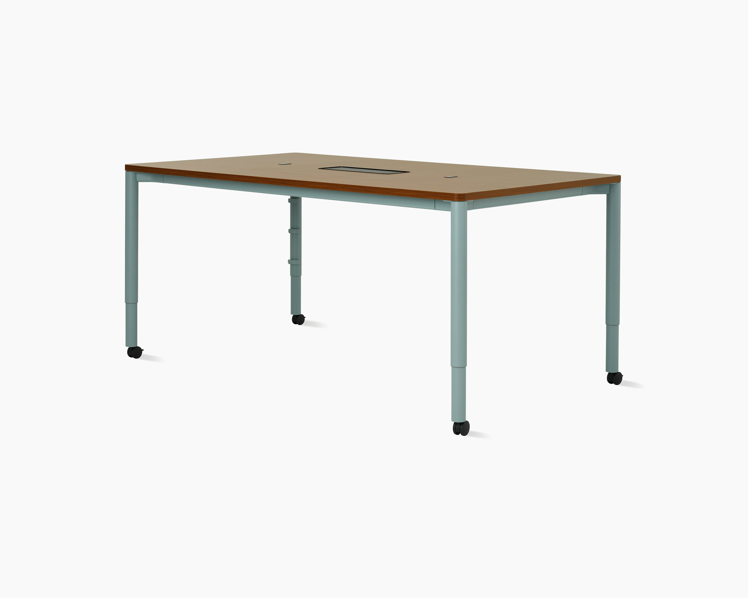 Four leg height-adjustable meeting table shown at standing height on casters with a dark woodgrain surface, light blue legs and a tech bucket in middle of surface.
