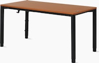 Four leg height-adjustable table with a woodgrain surface and black legs.
